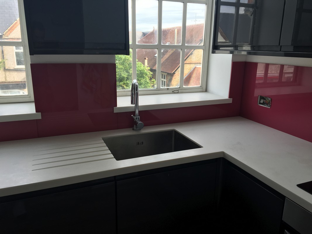 Deep plum coloured glass splashback in modern Caterham kitchen